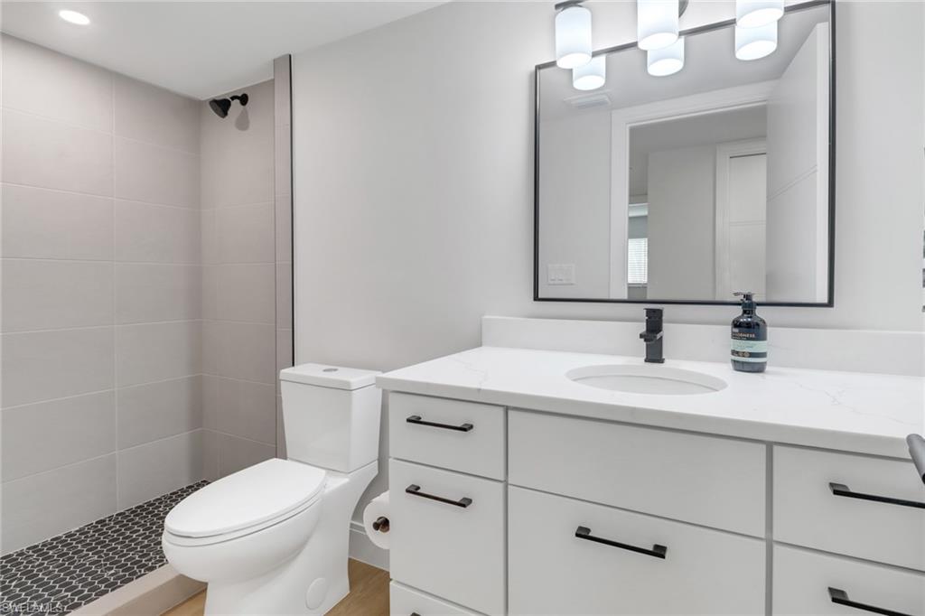 4150 Crayton Road, Unit B3 Naples, FL 34103 - Photo 13 of 19 a bathroom with a sink a toilet a mirror and shower
