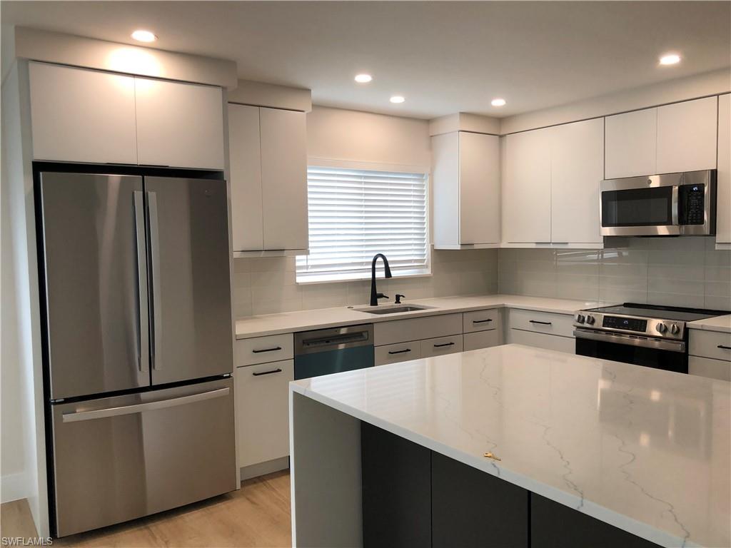 4150 Crayton Road, Unit B3 Naples, FL 34103 - Photo 4 of 19 a kitchen with stainless steel appliances a refrigerator sink and microwave