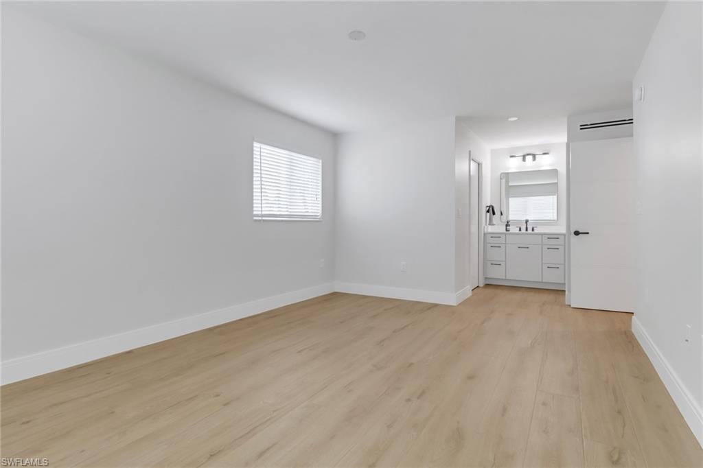 4150 Crayton Road, Unit B3 Naples, FL 34103 - Photo 10 of 19 wooden floor in an empty room with a window