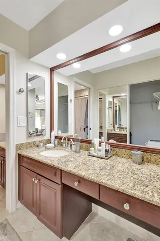 a bathroom with a granite countertop sink and a mirror