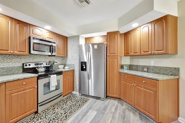 a kitchen with stainless steel appliances granite countertop a stove a sink and a microwave