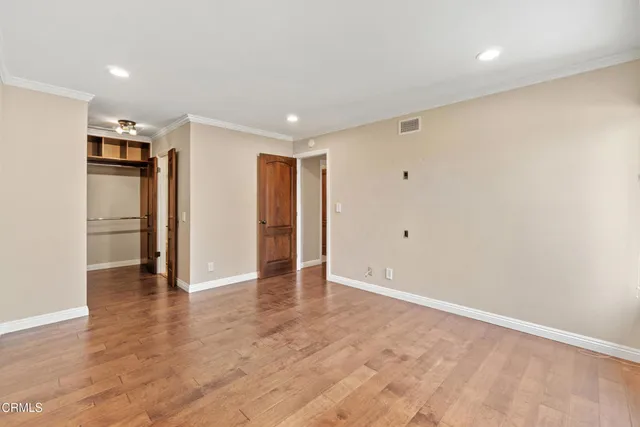 a view of an empty room with wooden floor
