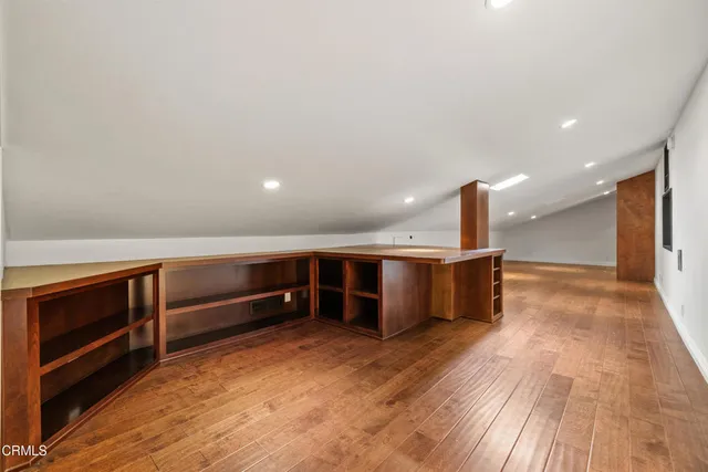 a view of an empty room with furniture and wooden floor