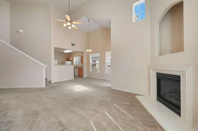 a view of a livingroom with a fireplace and a chandelier fan