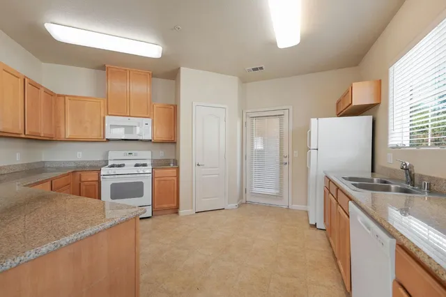 a kitchen with granite countertop a sink stove and refrigerator