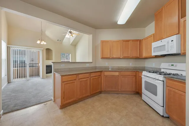 a kitchen with stainless steel appliances granite countertop a stove sink and cabinets