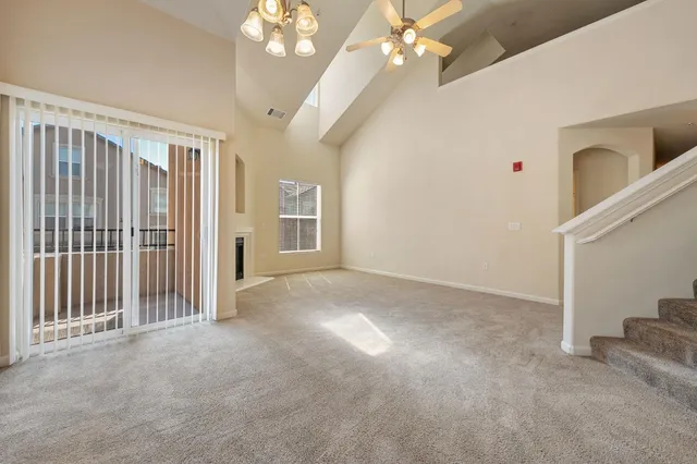 an empty room with windows and ceiling fan