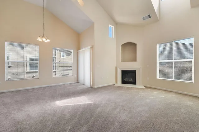 an empty room with windows and fireplace