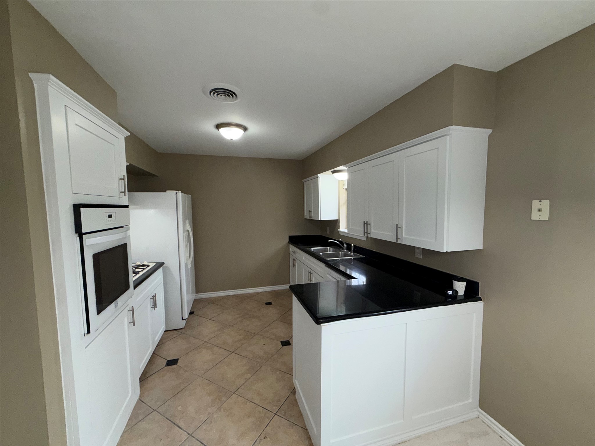 7306 Troulon Drive Houston, TX 77074 - Photo 5 of 16 a kitchen with granite countertop white cabinets and stainless steel appliances