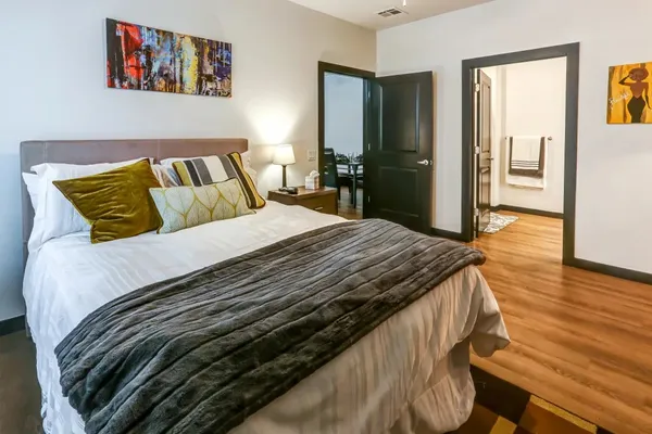 a bedroom with a bed and wooden floor