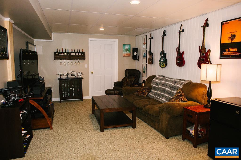 141 Tulip Road Ruckersville, VA 22968 - Photo 38 of 47 a living room with furniture a flat screen tv and gym equipment