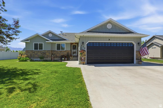 772 East 600 South Preston, ID 83263 - Photo 2 of 35 Ranch-style residence featuring a stone and siding exterior, a two-car garage with transom windows, and a concrete driveway