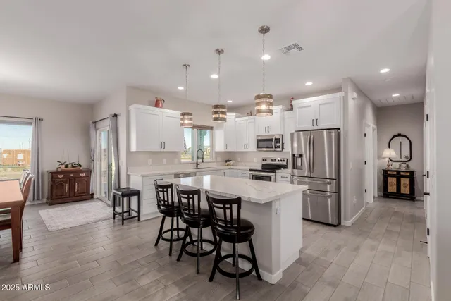 a kitchen with refrigerator and chairs