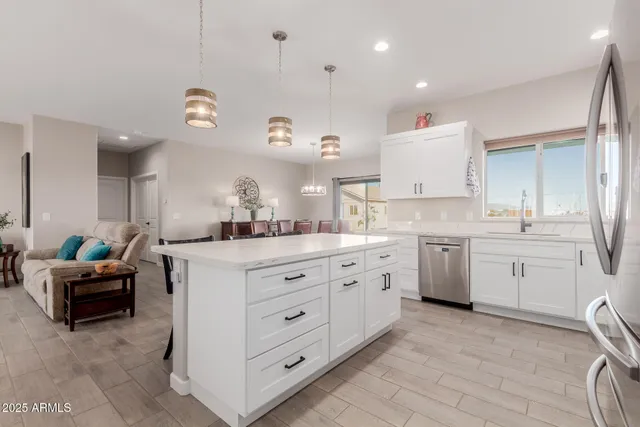 a large white kitchen with a lot of counter space and a sink