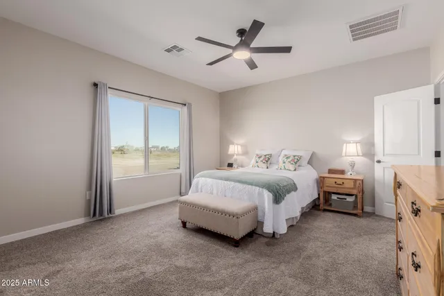 a spacious bedroom with a bed and a ceiling fan