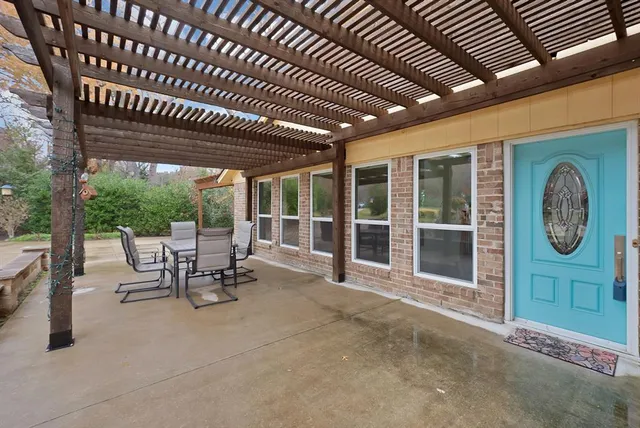 a view of a patio with table and chairs with wooden floor and fence