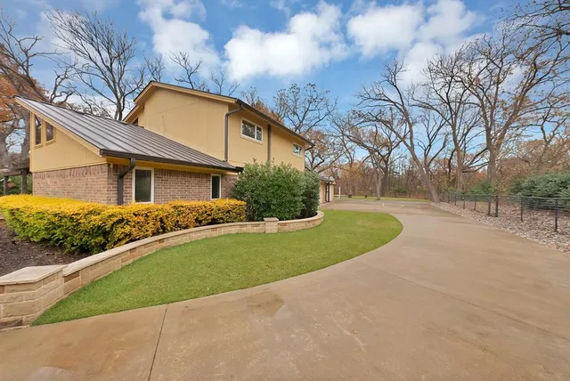 a view of a big house with a big yard and large tree