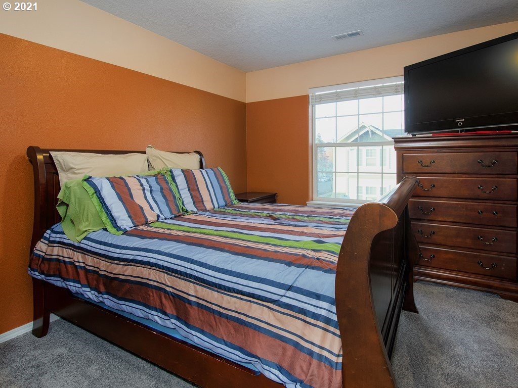 20078 Southwest Monson Street Beaverton, OR 97003 - Photo 16 of 32 a bedroom with a bed and a flat screen tv