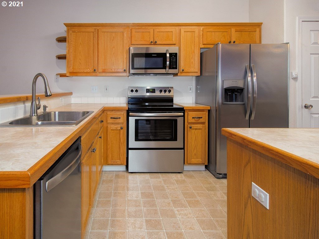 20078 Southwest Monson Street Beaverton, OR 97003 - Photo 8 of 32 a kitchen with stainless steel appliances granite countertop a stove a sink and a microwave