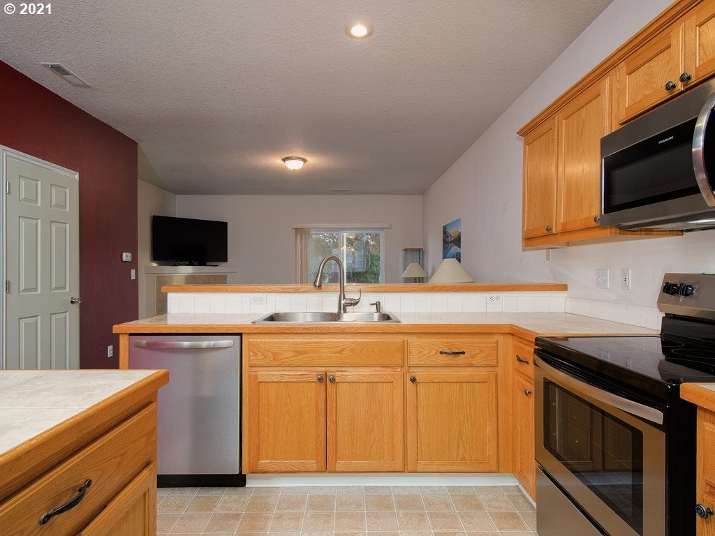 20078 Southwest Monson Street Beaverton, OR 97003 - Photo 10 of 32 a kitchen with a sink stove and microwave