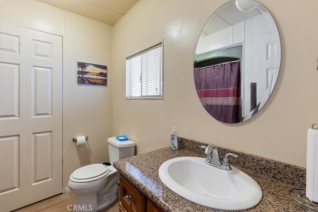 300 North Rampart Street, Unit 195 Orange, CA 92868 - Photo 15 of 25 a bathroom with a toilet a sink and mirror