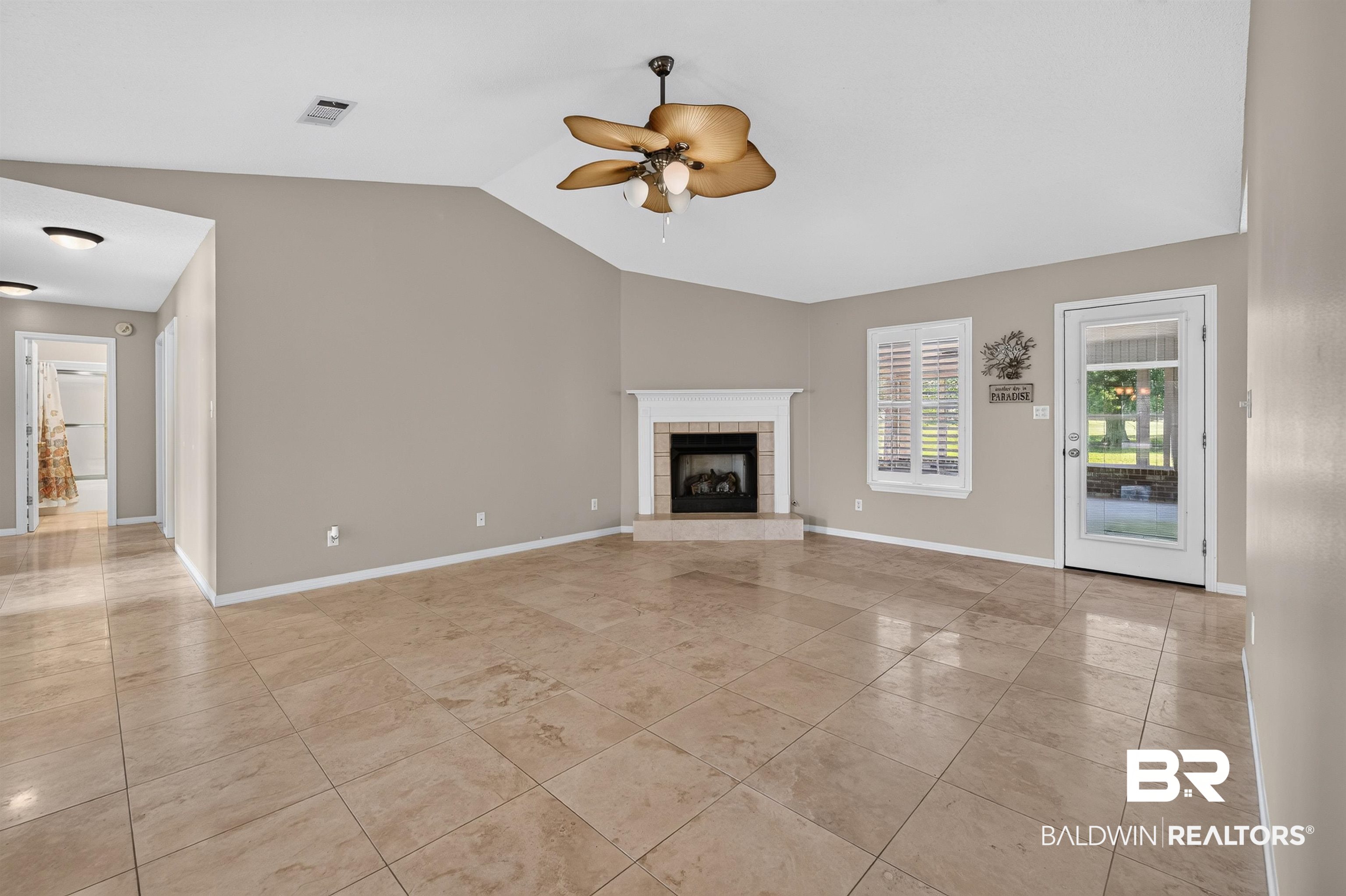 22685 County Road 12 Foley, AL 36535 - Photo 34 of 89 Spacious living area featuring vaulted ceilings, a corner fireplace with a white mantel, and neutral-toned tile flooring