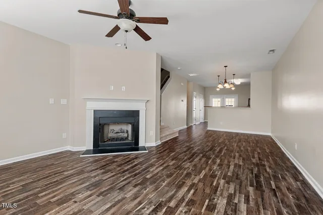 a view of empty room with wooden floor and fireplace