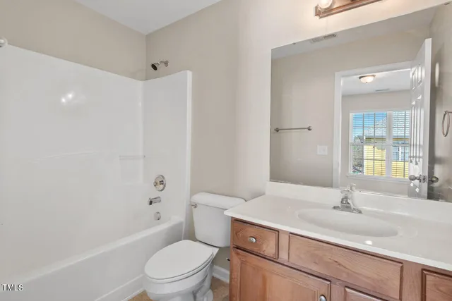 a bathroom with a sink toilet vanity and shower