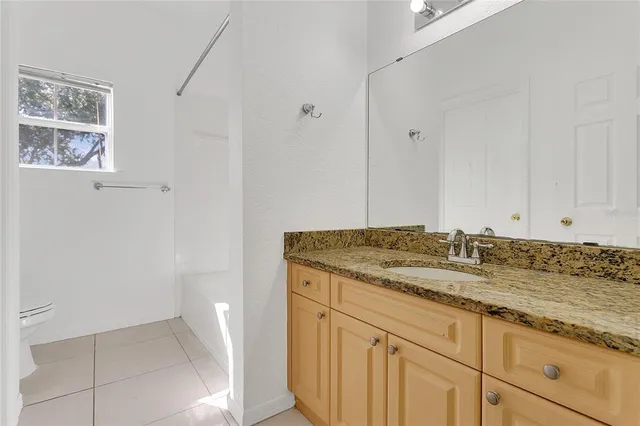a bathroom with a granite countertop sink and white cabinets