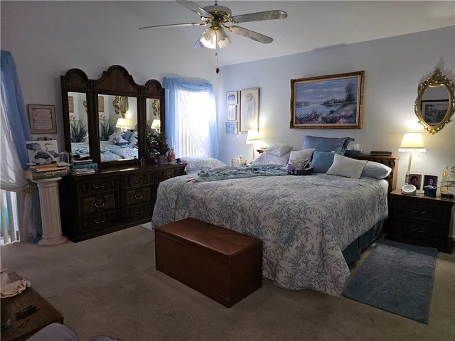 a bedroom with a bed and a chandelier with a flat tv screen