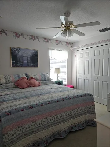 a bed room with a bed and a ceiling fan
