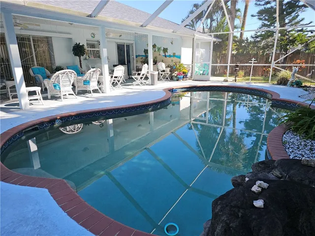 a view of a house with backyard and sitting area