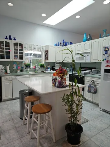a room with stainless steel appliances a sink a table and chairs