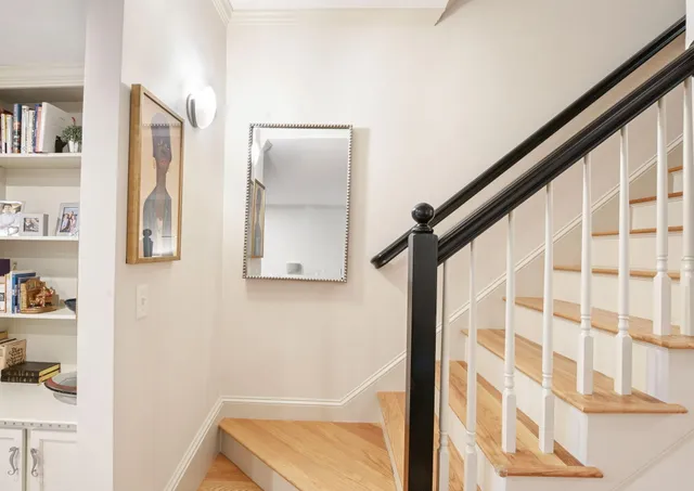a bed sitting in a bedroom next to a window with a chair