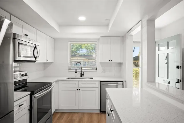 a kitchen with stainless steel appliances granite countertop a sink stove and refrigerator