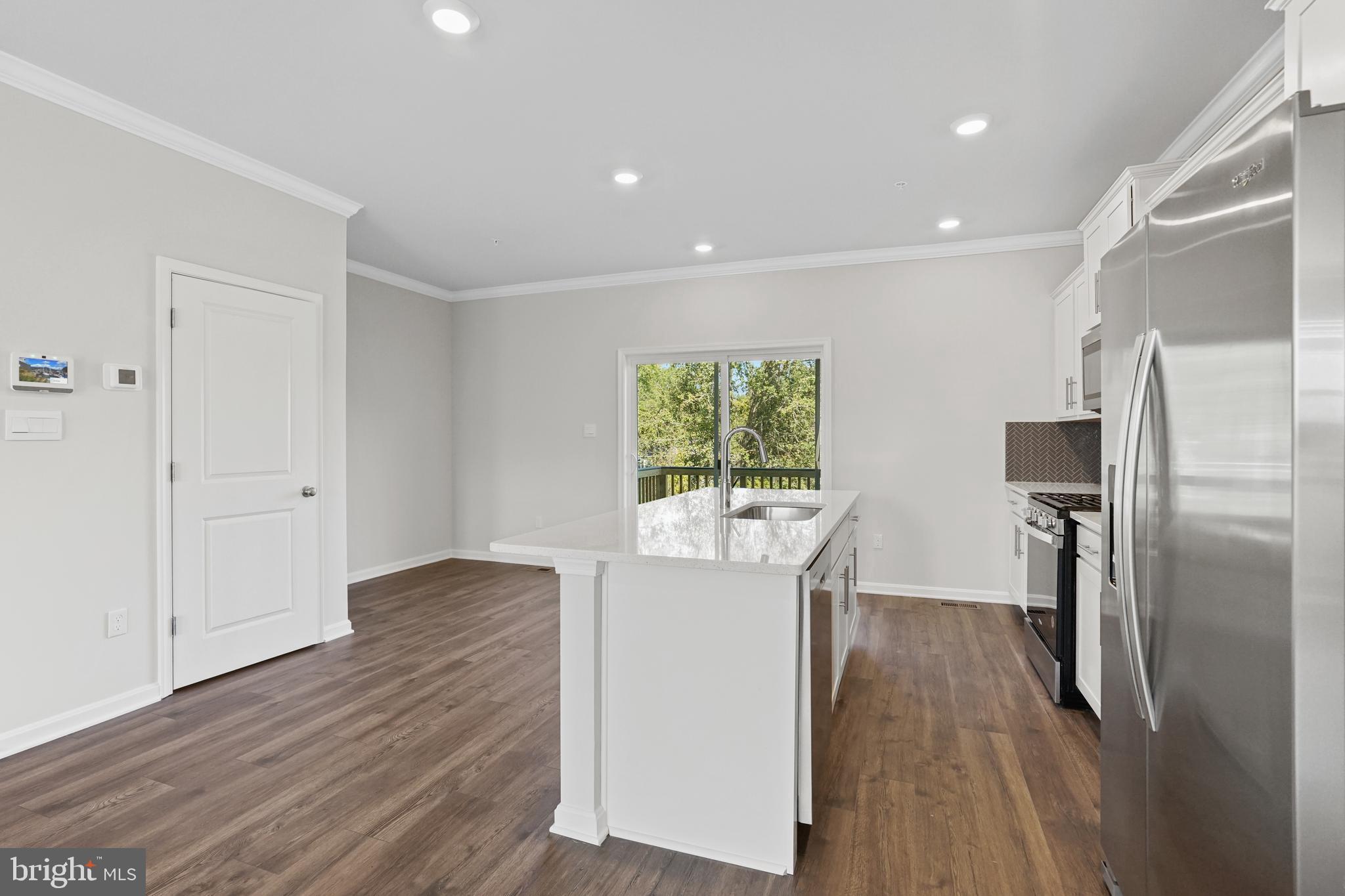 8709 Tavern Street Clinton, MD 20735 - Photo 17 of 25 a kitchen with stainless steel appliances a refrigerator sink and wooden floor
