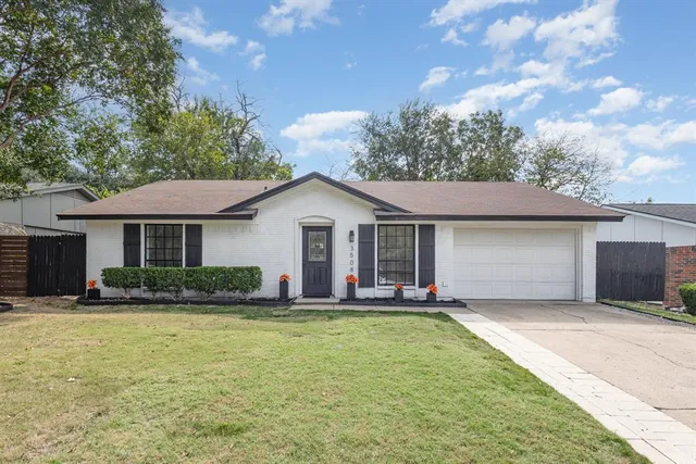 a front view of house with yard and trees in the background
