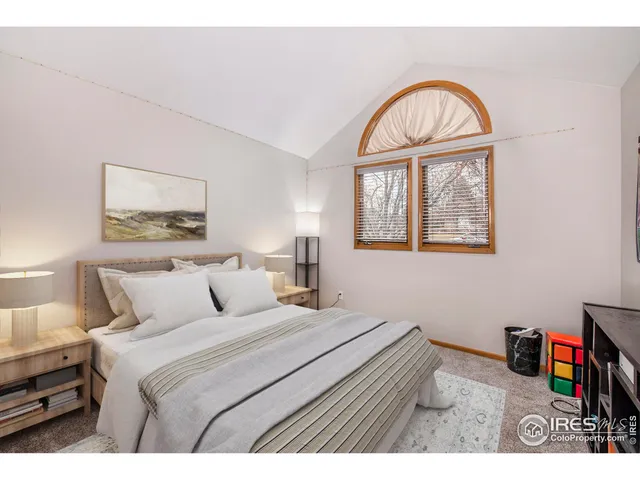 a bedroom with a bed and a painting on the wall
