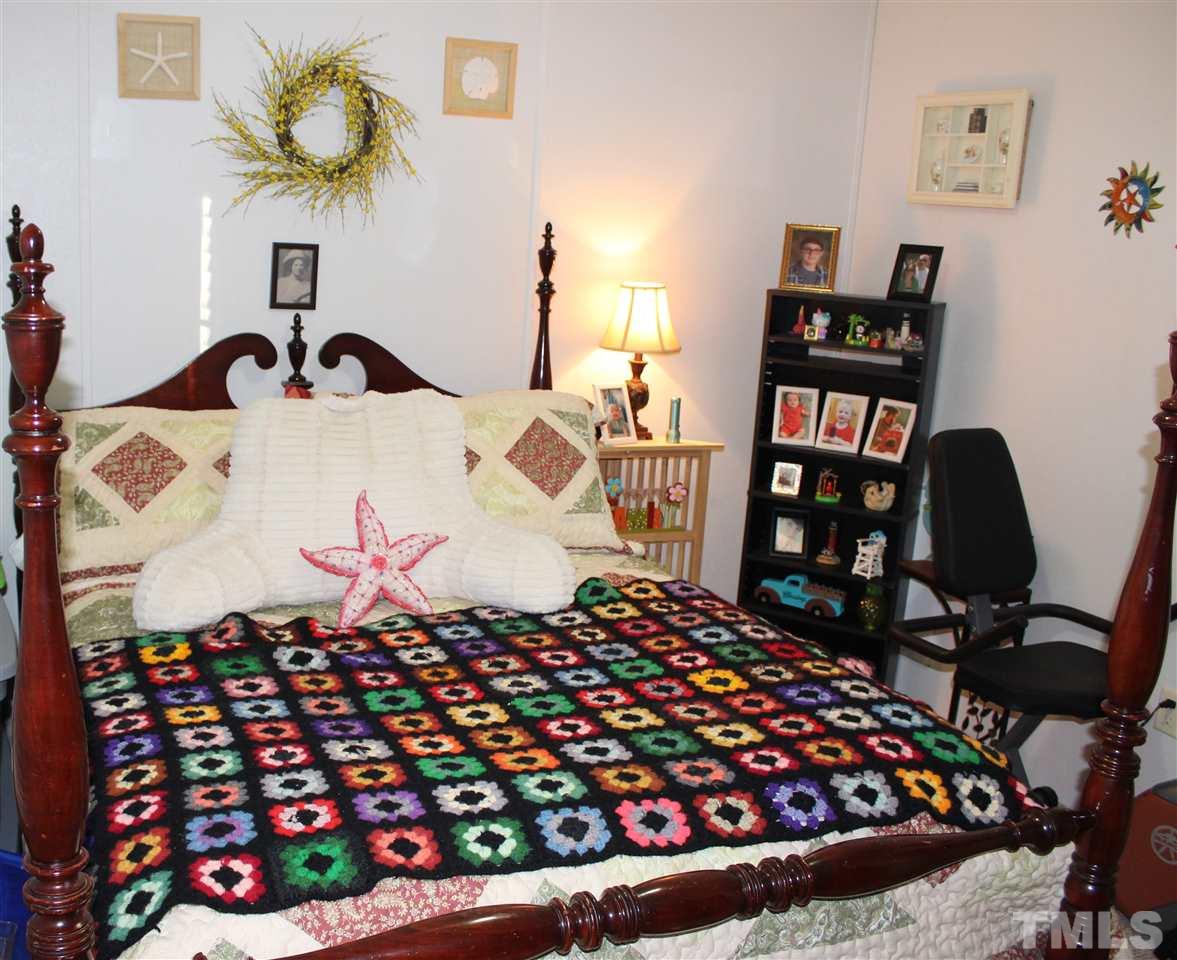 141 Waters Edge Road Henderson, NC 27537 - Photo 15 of 30 a bedroom with a bed and a book shelf