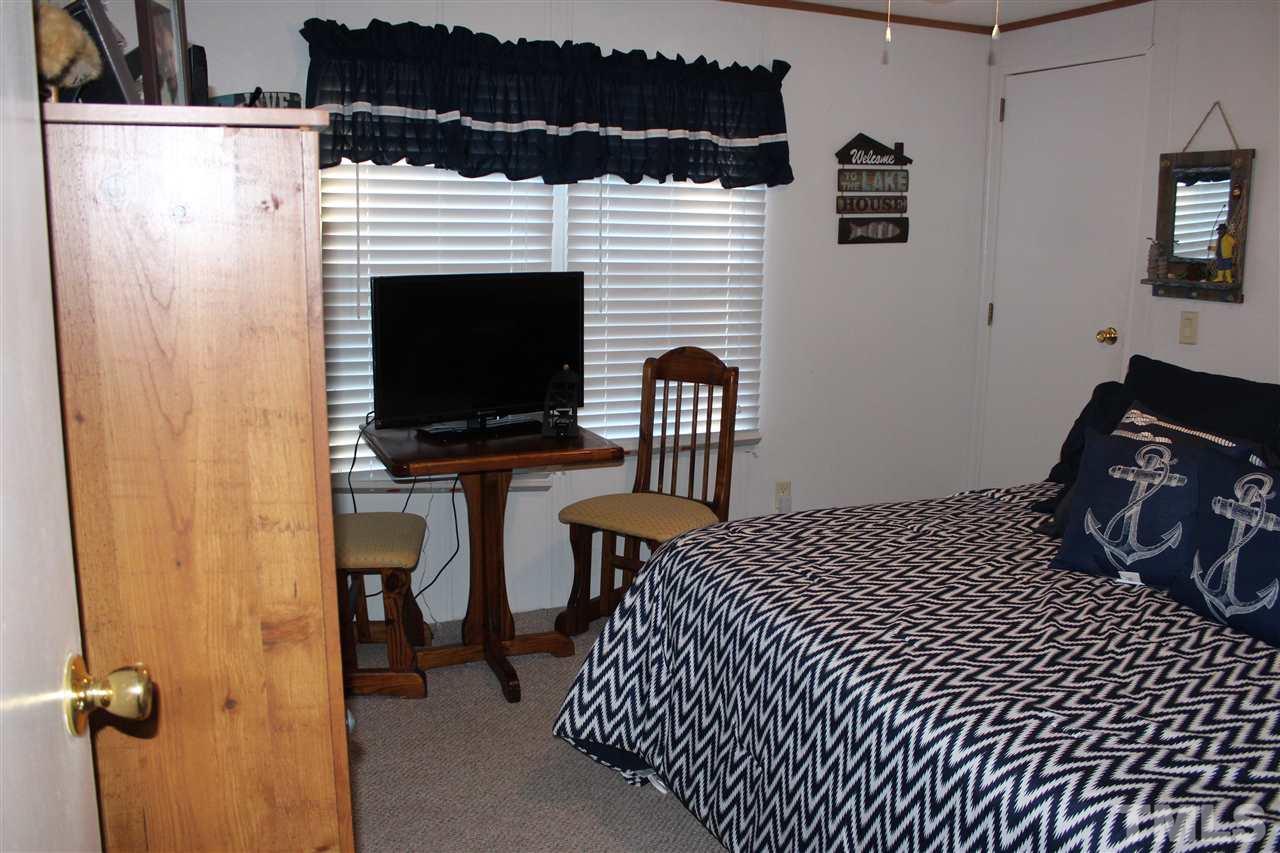 141 Waters Edge Road Henderson, NC 27537 - Photo 18 of 30 a bedroom with a bed and a television