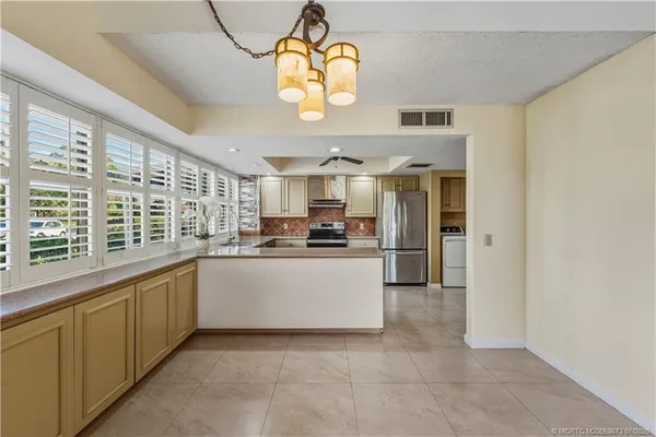 a kitchen with stainless steel appliances granite countertop a stove cabinets and a refrigerator