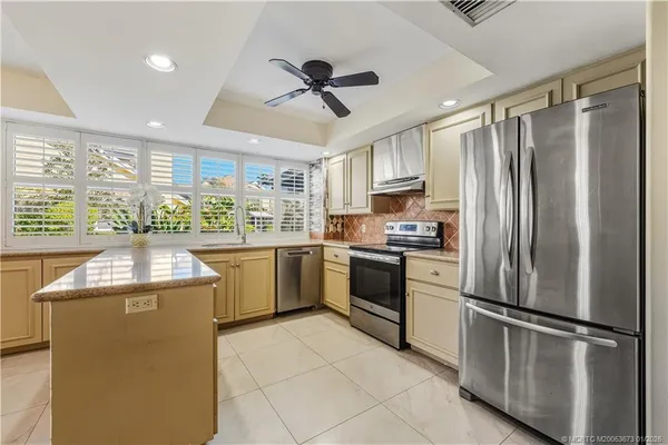 a kitchen with granite countertop stainless steel appliances and white cabinets