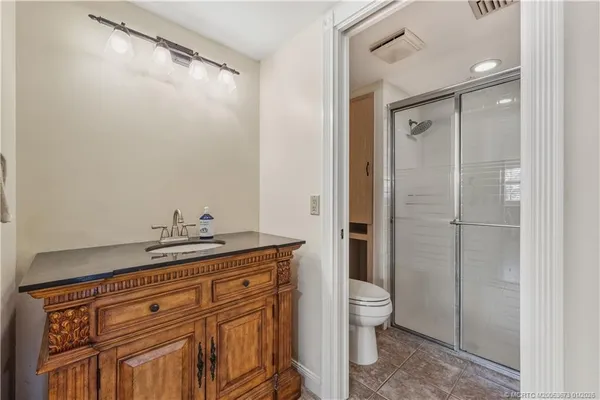a bathroom with a granite countertop sink a toilet and shower