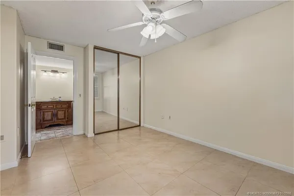 an empty room with a ceiling fan and a bathroom