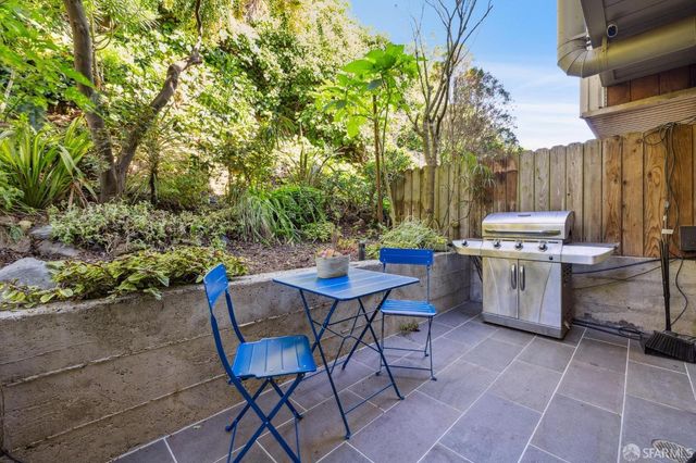 a living room with patio furniture and potted plants