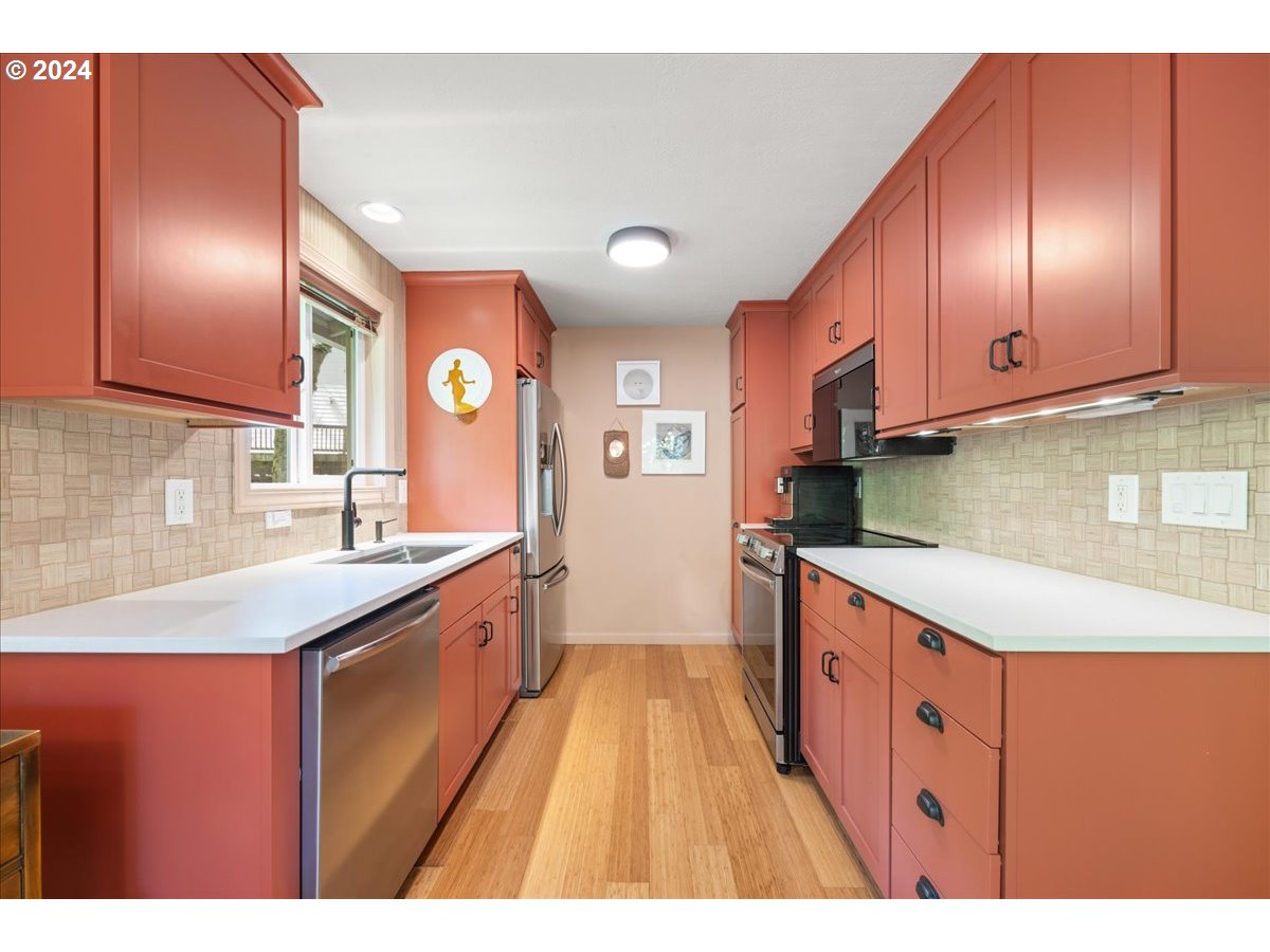 4432 Northwest Barnes Road Portland, OR 97210 - Photo 12 of 36 a large kitchen with stainless steel appliances granite countertop a sink a stove and a refrigerator