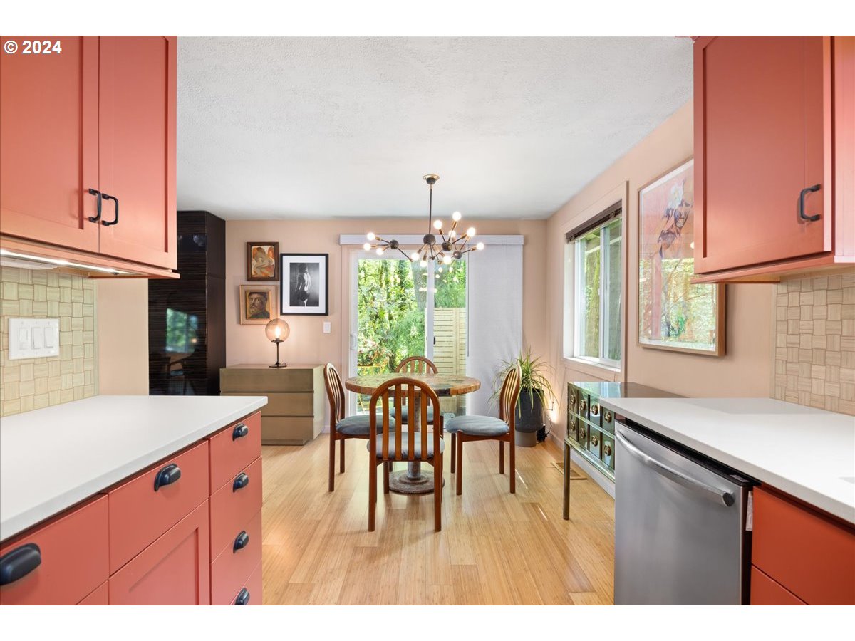 4432 Northwest Barnes Road Portland, OR 97210 - Photo 14 of 36 a open kitchen with stainless steel appliances granite countertop a dining table chairs and a refrigerator a sink