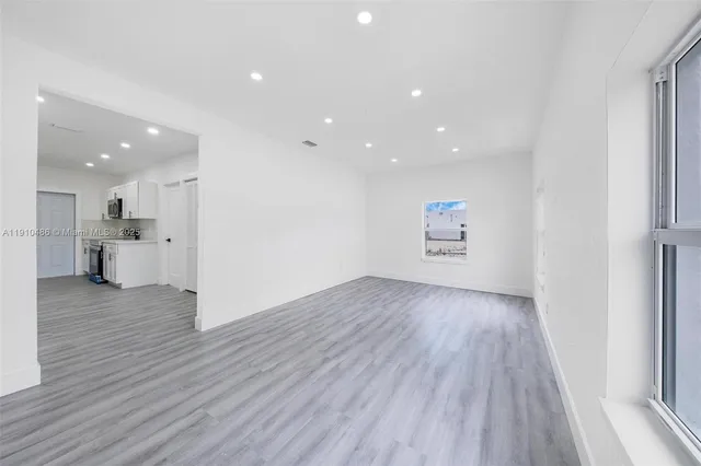 a view of a kitchen with wooden floors and kitchen appliances
