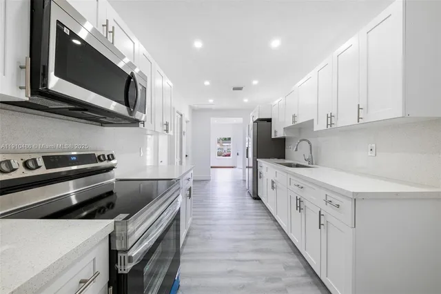 a kitchen with stainless steel appliances sink a microwave and cabinets