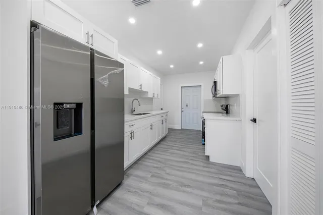 a kitchen with white cabinets and stainless steel appliances